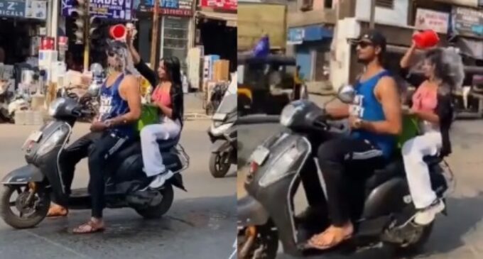 Beat the heat! Boy & girl take bath while riding scooter on road, watch